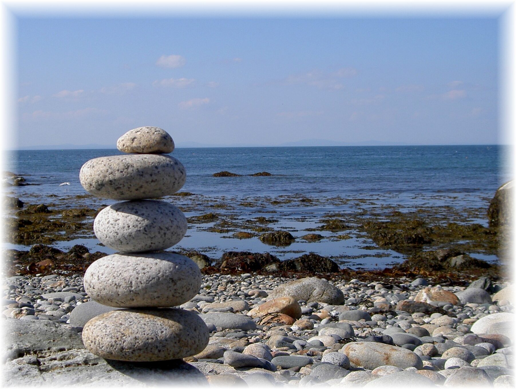 Picture of stones placed into a tower by the ocean.
